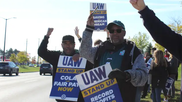 29-year autoworker Randy Harvard (right) is pictured with fellow United Auto Workers members following the union's call for a walkout on October 23, 2023, at Stellantis' Ram 1500 plant in Sterling Heights, Michigan.