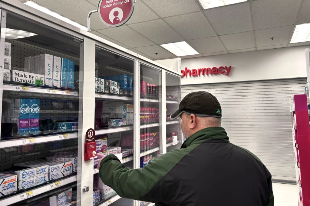 At a CVS in Queens, New York, a man presses a button to request employee assistance in order to obtain toothpaste.